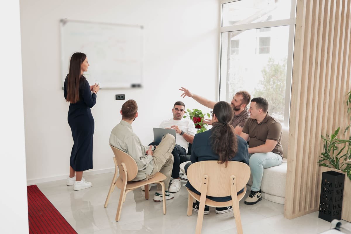 A TekPiq team member leading a design review at the whiteboard while engineers discuss